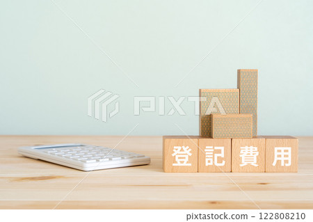 Blocks with "registration fees" written on them, a calculator, and a model of a real estate property 122808210