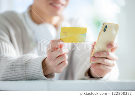 Young man looking at smartphone and credit card 122808352