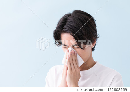 Image of a man holding a tissue to his nose (stock photo) 122808369