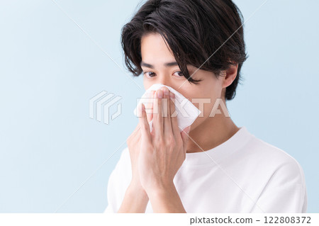 Image of a man holding a tissue to his nose (stock photo) Image of a man holding a tissue to his nose (stock photo) 122808372