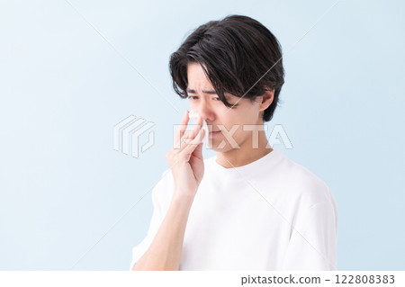Image of a man holding a tissue to his nose (stock photo) Image of a man holding a tissue to his nose (stock photo) 122808383