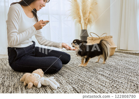 Woman playing with her dog in the living room Woman playing with her dog in the living room 122808780