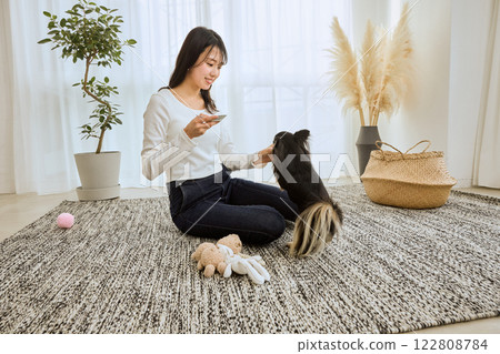 女人在客廳和她的狗玩耍 女人在客廳和她的狗玩耍 122808784