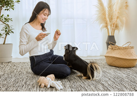 女人在客廳和她的狗玩耍 122808788