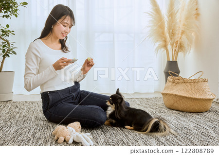 女人在客廳和她的狗玩耍 女人在客廳和她的狗玩耍 122808789