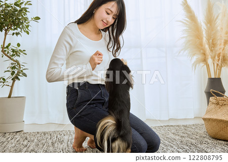 女人在客廳和她的狗玩耍 122808795