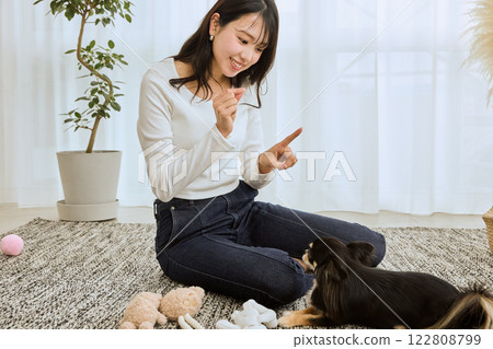 Woman playing with her dog in the living room Woman playing with her dog in the living room 122808799