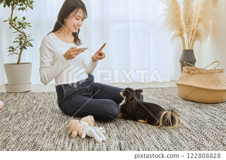 女人在客廳和她的狗玩耍 122808828
