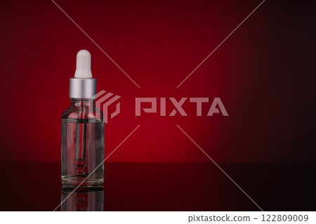 Glass Dropper Bottle with Silver Cap and Empty Space for Text on Red Background Glass Dropper Bottle with Silver Cap and Empty Space for Text on Red Background 122809009