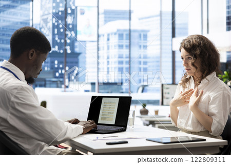 HR manager interviewing woman after doing background checks to job applicant. African american HR professional reading resume and discussing with candidate for vacant startup business position 122809311