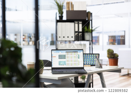 Empty company financial department with stock portfolio on laptops containing collection of investment assets. Workspace with live index indices on notebook screen showing stock demand surge 122809382