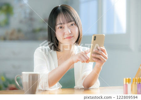 一個操作智能手機的年輕女子 122809594