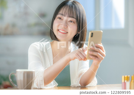 一個操作智能手機的年輕女子 122809595