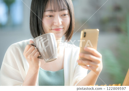 一個操作智能手機的年輕女子 122809597