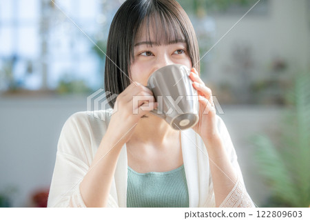 A woman drinking coffee A woman drinking coffee 122809603