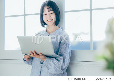 使用個人計算機的一個少婦在屋子裡 122809606