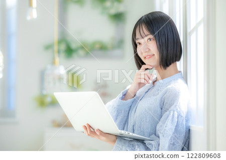 A young woman using a personal computer in the room A young woman using a personal computer in the room 122809608