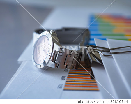 Graphs, documents, and a wristwatch on the table Graphs, documents, and a wristwatch on the table 122810744