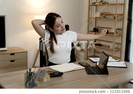 young businesswoman is stretching her body to relieve fatigue from working young businesswoman is stretching her body to relieve fatigue from working 122811098