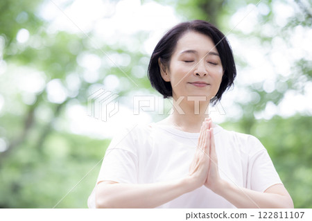 Middle-aged woman stretching in the park 122811107