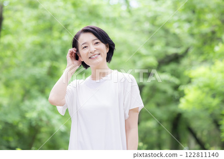 Middle-aged woman walking in the park Middle-aged woman walking in the park 122811140