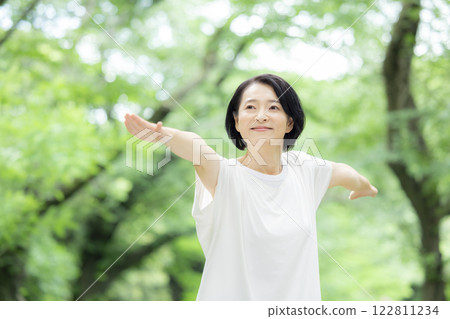 Middle-aged woman stretching in the park 122811234
