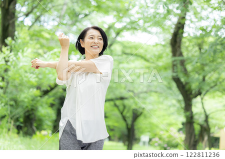 Middle-aged woman stretching in the park 122811236