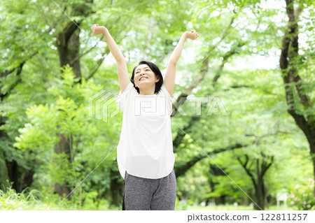 Middle-aged woman stretching in the park 122811257