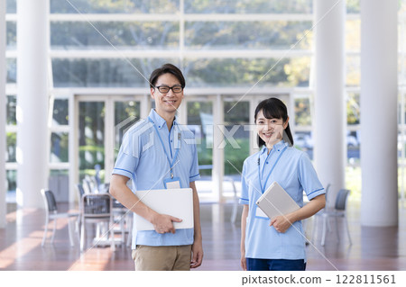 Two male and female facility staff members smiling at the camera Two male and female facility staff members smiling at the camera 122811561