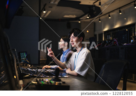 A director working in a broadcasting station's control room 122812055