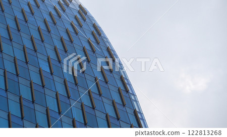 Curved Glass Facade - Modern skyscraper with repeating geometric patterns and a sleek curvature, perfect for showcasing architectural innovation, urban design concepts, or modern minimalism Curved Glass Facade - Modern skyscraper with repeating geometric patterns and a sleek curvature, perfect for showcasing architectural innovation, urban design concepts, or modern minimalism 122813268