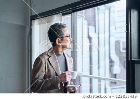 man drinking coffee by the window 122813439