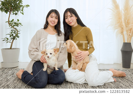 女人在客廳和她的狗玩耍 女人在客廳和她的狗玩耍 122813582