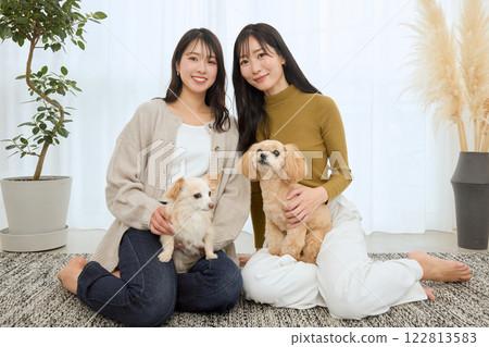 Woman playing with her dog in the living room Woman playing with her dog in the living room 122813583