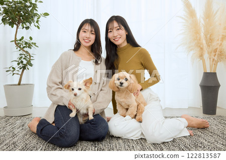Woman playing with her dog in the living room 122813587
