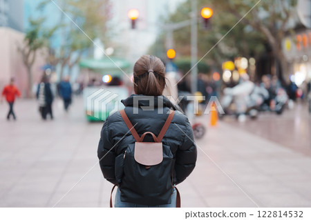 woman traveler visiting in Shanghai, China. Happy Female Tourist sightseeing in Nanjing road, shopping district of Shanghai. landmark and popular for tourism attractions. Travel and Vacation concept 122814532