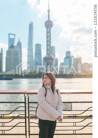 woman traveler visiting in Shanghai, China. Happy Female Tourist sightseeing Shanghai view of Lujiazui in The north Bund of Shanghai. landmark and popular for tourism attractions. Vacation concept 122814556