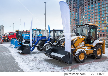 Two wheeled tractors, a bulldozer and snow removal equipment at an industrial exhibition in winter Two wheeled tractors, a bulldozer and snow removal equipment at an industrial exhibition in winter 122814695