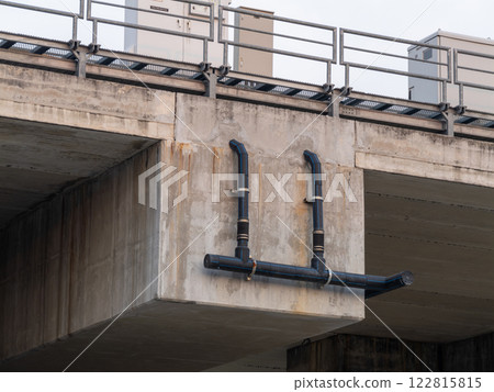 Urban infrastructure elevated industrial pipe installation over concrete bridge 122815815