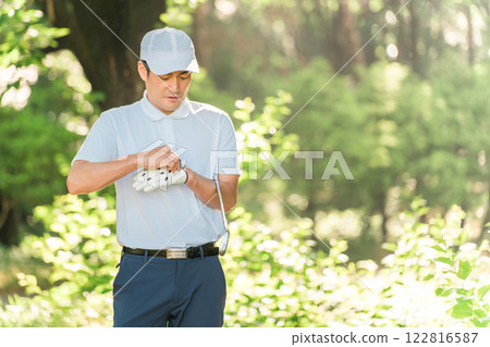 A male golfer wearing golf wear among the fresh greenery 122816587