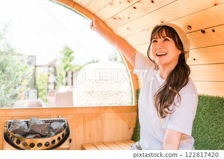 一位亞洲年輕女性在桑拿房裡戴著桑拿帽 一位亞洲年輕女性在桑拿房裡戴著桑拿帽 122817420