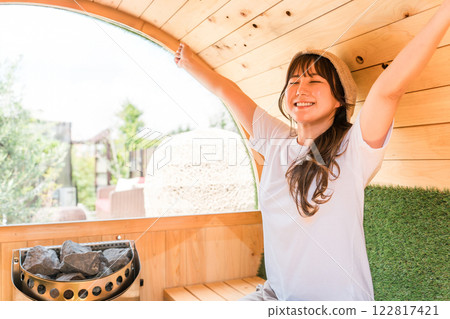 一位亞洲年輕女性在桑拿房裡戴著桑拿帽 122817421