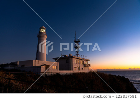 White lighthouse lit by the morning sun 122817581