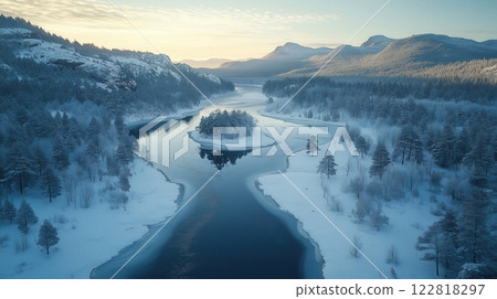 Winter river winding through a snow-covered valley, with trees and distant mountains 122818297