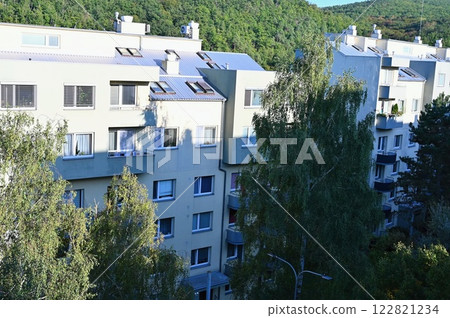 Original prefabricated houses on a housing estate from the communist era in Eastern and Central Europe after reconstruction.. Facade of a modern apartment building with windows and balconies. Czech Original prefabricated houses on a housing estate from the communist era in Eastern and Central Europe after reconstruction.. Facade of a modern apartment building with windows and balconies. Czech 122821234