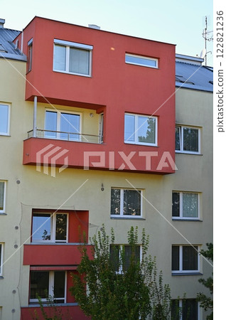 Original prefabricated houses on a housing estate from the communist era in Eastern and Central Europe after reconstruction.. Facade of a modern apartment building with windows and balconies. Czech 122821236