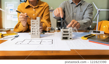 Drawing working on blueprint meeting for project working with partner on model building at company office. 122823390