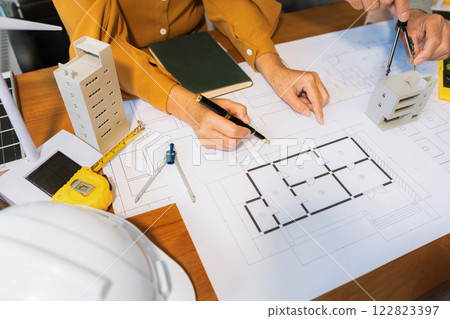 Architect team working with blueprints for sketching a construction project. 122823397