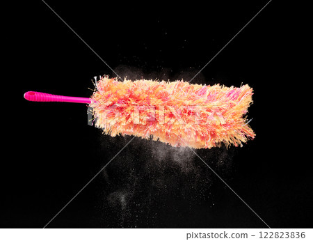 Orange microfiber Duster stick made from synthetic to clean house dust and web. Room Ceiling and window covered with dust bunnies, cobweb cleaned by microfiber duster stick. Black background isolated 122823836