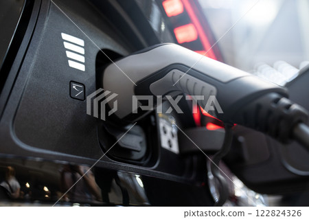 Close up of electric car inlet with a connected charging cable Close up of electric car inlet with a connected charging cable 122824326